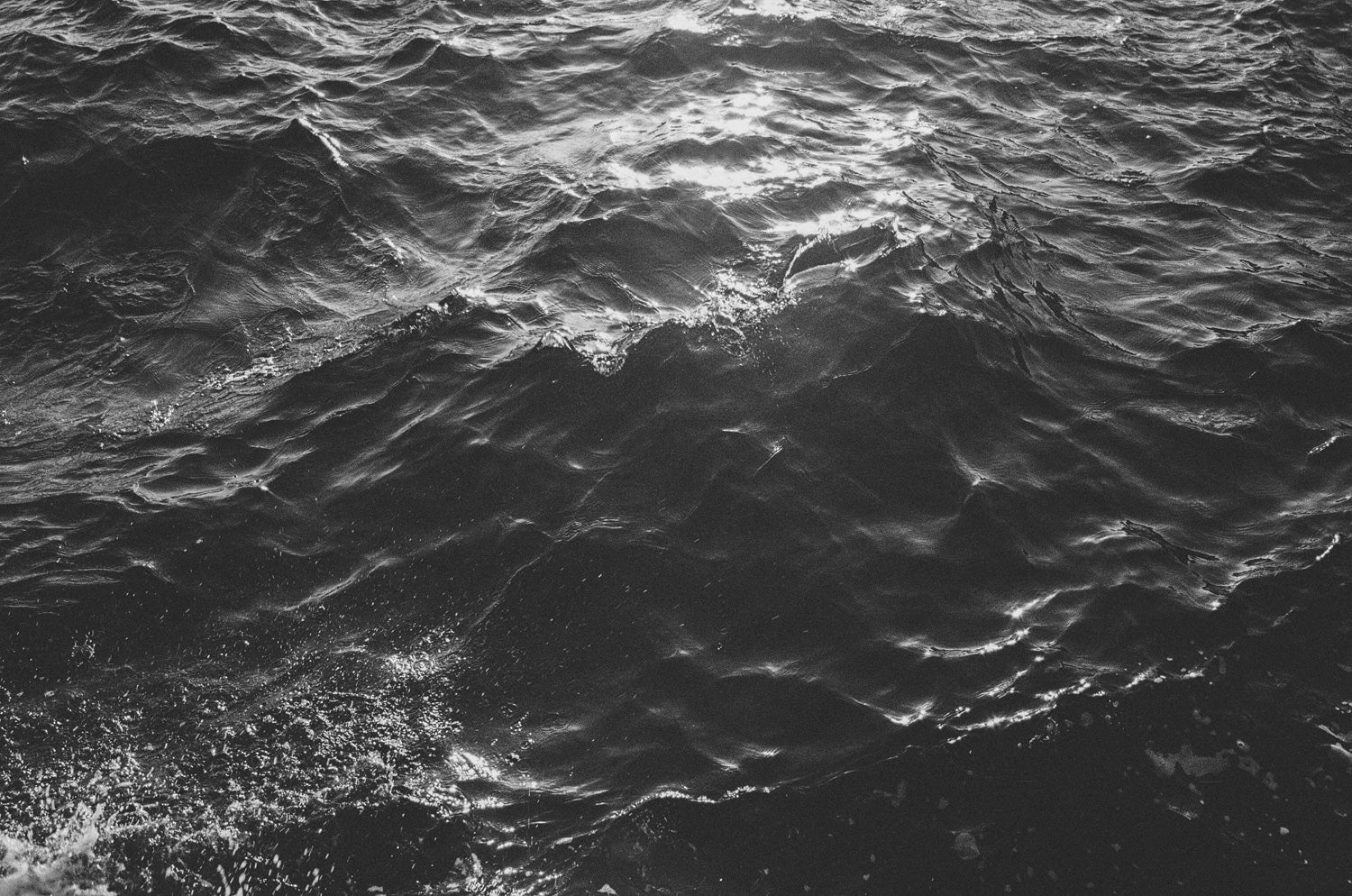 Schwarz-Weiß Detailaufnahme von einer unruhigen Wasseroberfläche